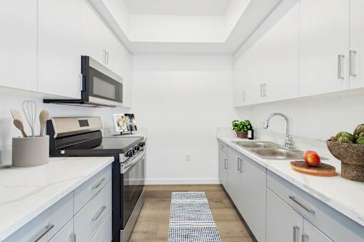 A kitchen with white cabinets and a black stove top oven.