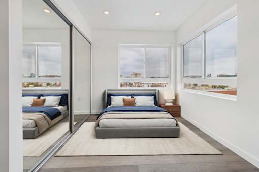 A bedroom with a large bed and a view of the city.