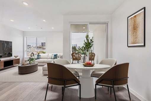 A modern dining room with a white table and chairs.