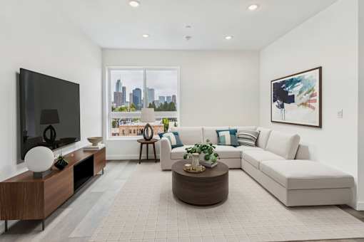 A modern living room with a large window overlooking the city.