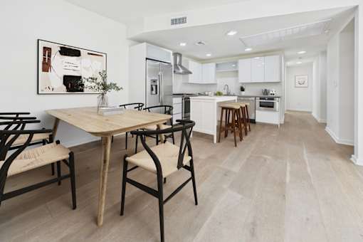 A kitchen with a table and chairs in front of it.