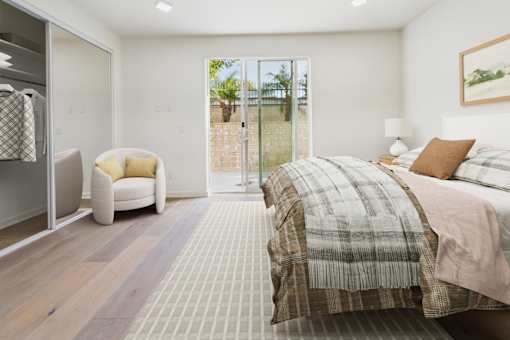 A bedroom with a large bed and a chair.