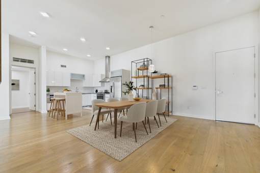 A modern dining room with a wooden table and chairs.