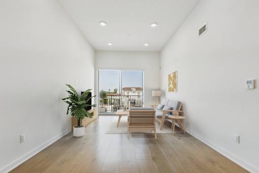 A living room with a wooden floor and a large window.