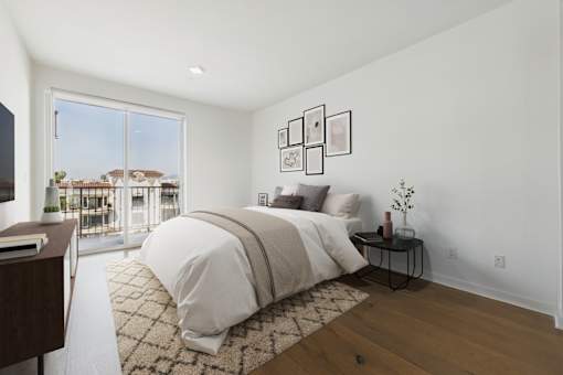 A bedroom with a large bed and a view of a house through the window.