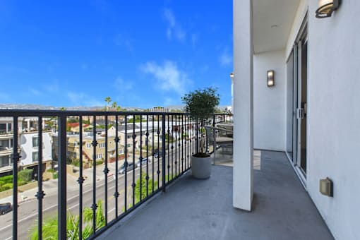A balcony with a black railing and a white wall.