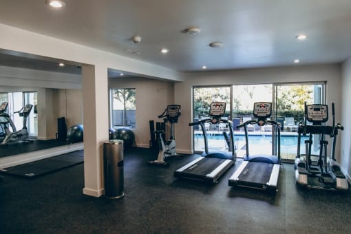 Brand New Fitness Center including treadmill, stationary bike, yoga with a pool view