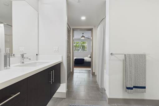 A bathroom with a white sink and a mirror.