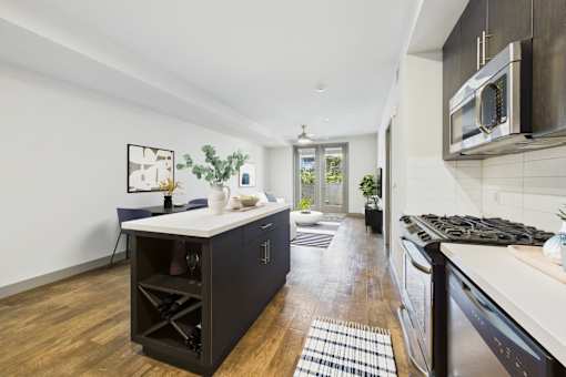 A kitchen with a white countertop and a black cabinet.