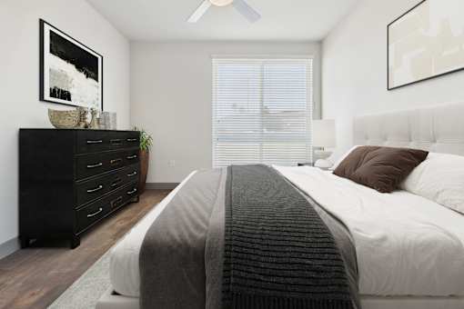 A bedroom with a large bed and a dresser.