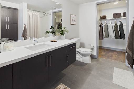 A bathroom with a white countertop and black cabinets.