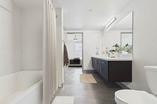 A bathroom with a white tub and a white toilet.