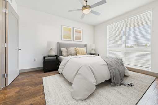 A bedroom with a bed, a ceiling fan, and a rug.