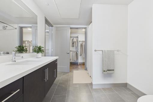 A bathroom with a sink, mirror, and towel rack.