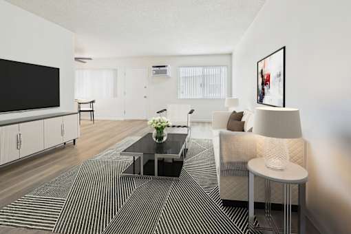 A modern living room with a black coffee table and a large flat screen TV.