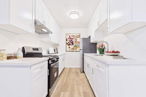 A kitchen with white cabinets and appliances.