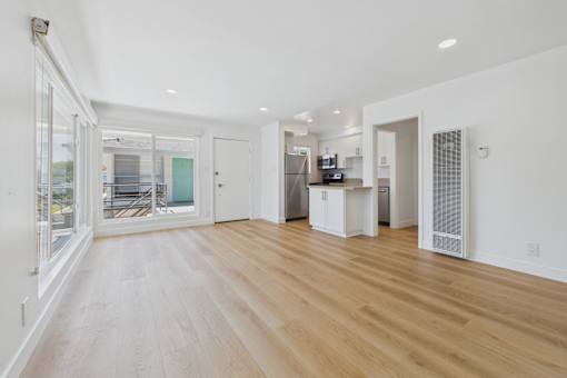 A spacious kitchen with a refrigerator, microwave, and oven.