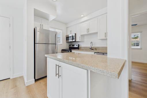 A kitchen with a granite countertop and stainless steel appliances.