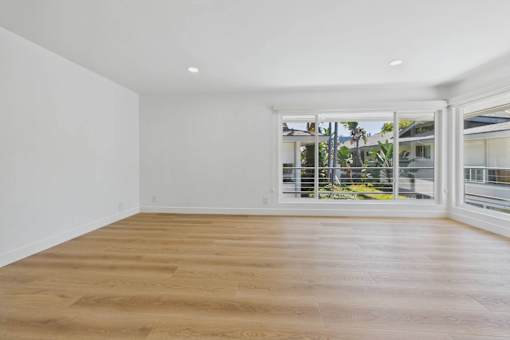 A room with wooden flooring and white walls.