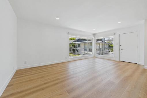 A room with wooden flooring and white walls.