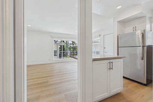 A kitchen with a refrigerator, cabinets, and a countertop.