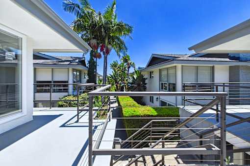 A modern house with a palm tree in front.