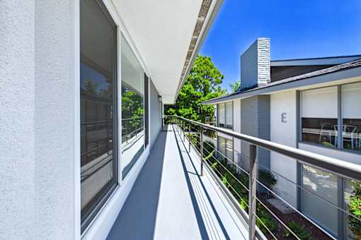 A balcony with a metal railing and glass doors leading to a patio.