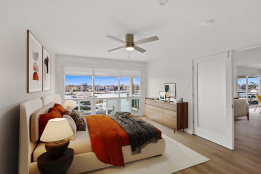 an apartment bedroom with a bed and a ceiling fan