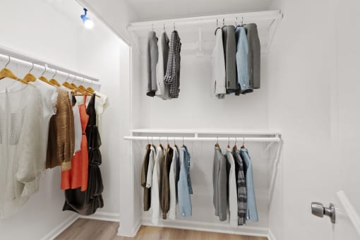 a closet with a rack of clothes on the wall