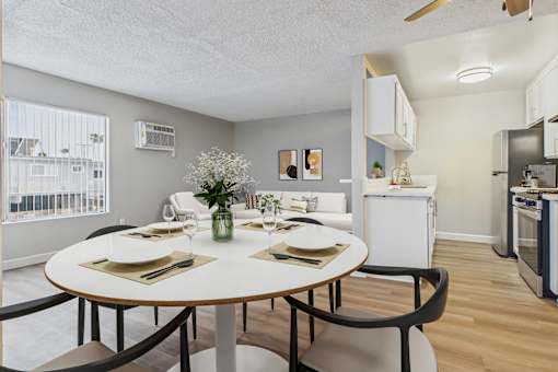 A dining room with a round table set for two.