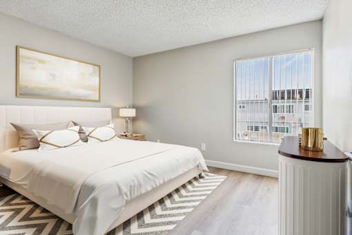 A bedroom with a large bed and a painting on the wall.