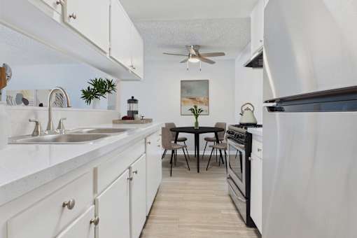 A kitchen with white cabinets and a black stove top oven.