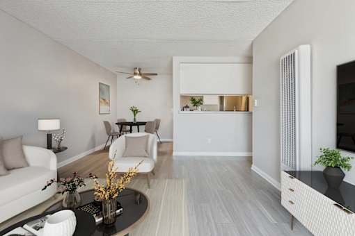 A living room with a white couch, a coffee table, and a ceiling fan.