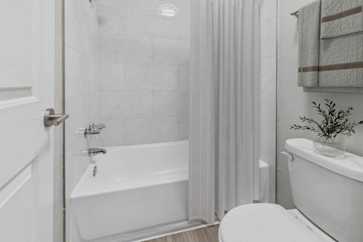 A white bathroom with a tub, toilet, and sink.