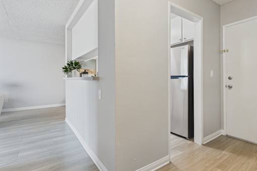 A kitchen with a white fridge and a white door.