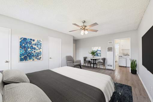A bedroom with a large bed and a ceiling fan.