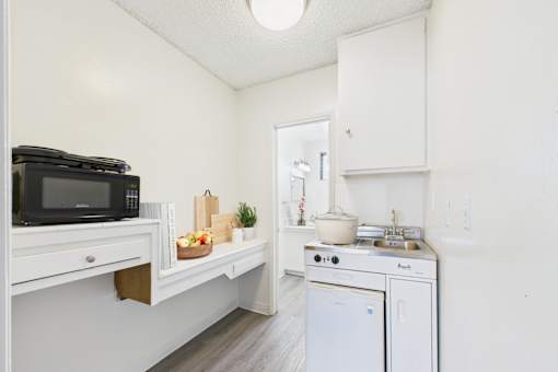A small kitchen with a microwave, oven, and sink.