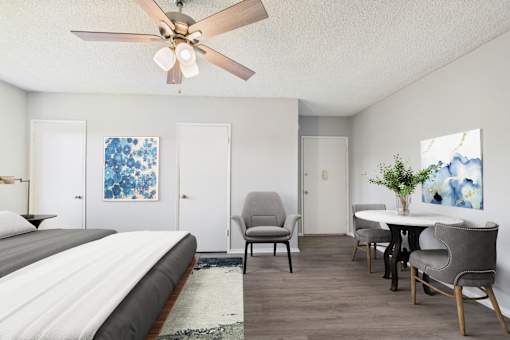A bedroom with a bed, chair, and table.