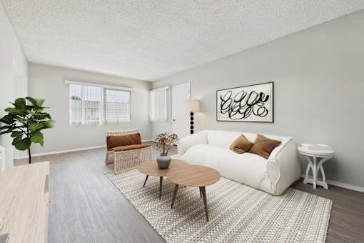 A living room with a white couch, a wooden coffee table, and a large plant.