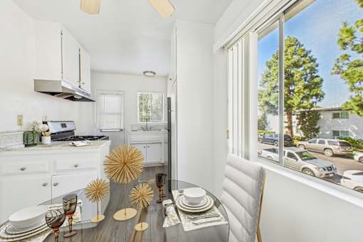 A modern kitchen with a dining table set for two.