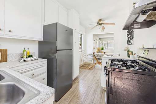 A modern kitchen with a black refrigerator and stove.