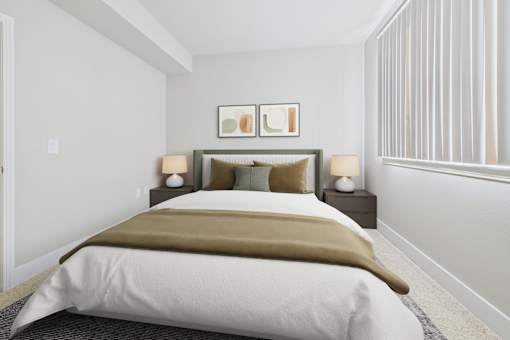 A bed with a white comforter and a brown throw is in a room with two lamps on the bedside tables.