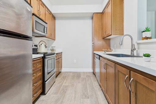A kitchen with wooden cabinets and a stainless steel refrigerator.