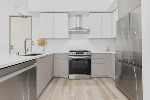 A modern kitchen with stainless steel appliances and white cabinetry.