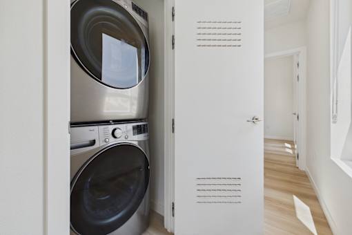 A washing machine is built into a wall in a small room.