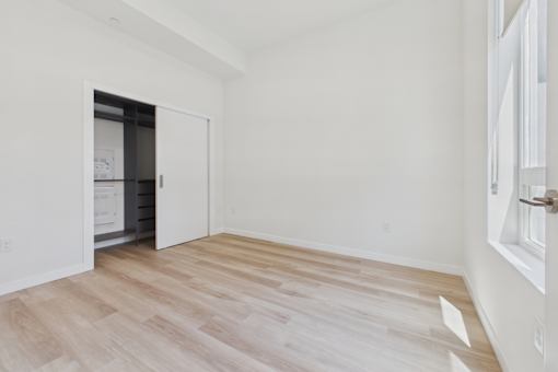 A room with a white wall and a wooden floor.