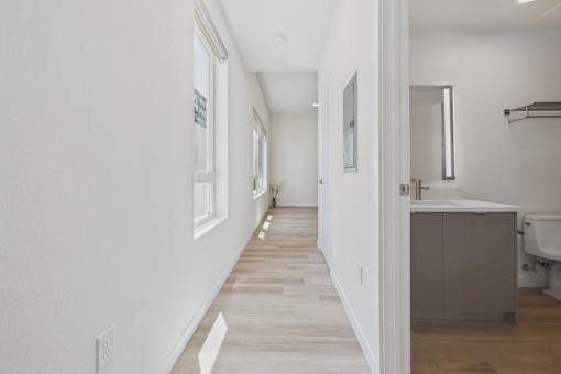 A long, narrow hallway with a bathroom on the right.