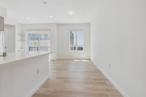 A long, empty hallway with wooden floors and white walls.