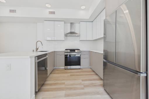 A modern kitchen with stainless steel appliances and white cabinetry.
