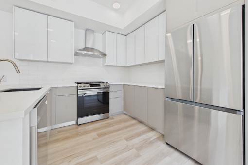 A modern kitchen with a stainless steel refrigerator and oven.